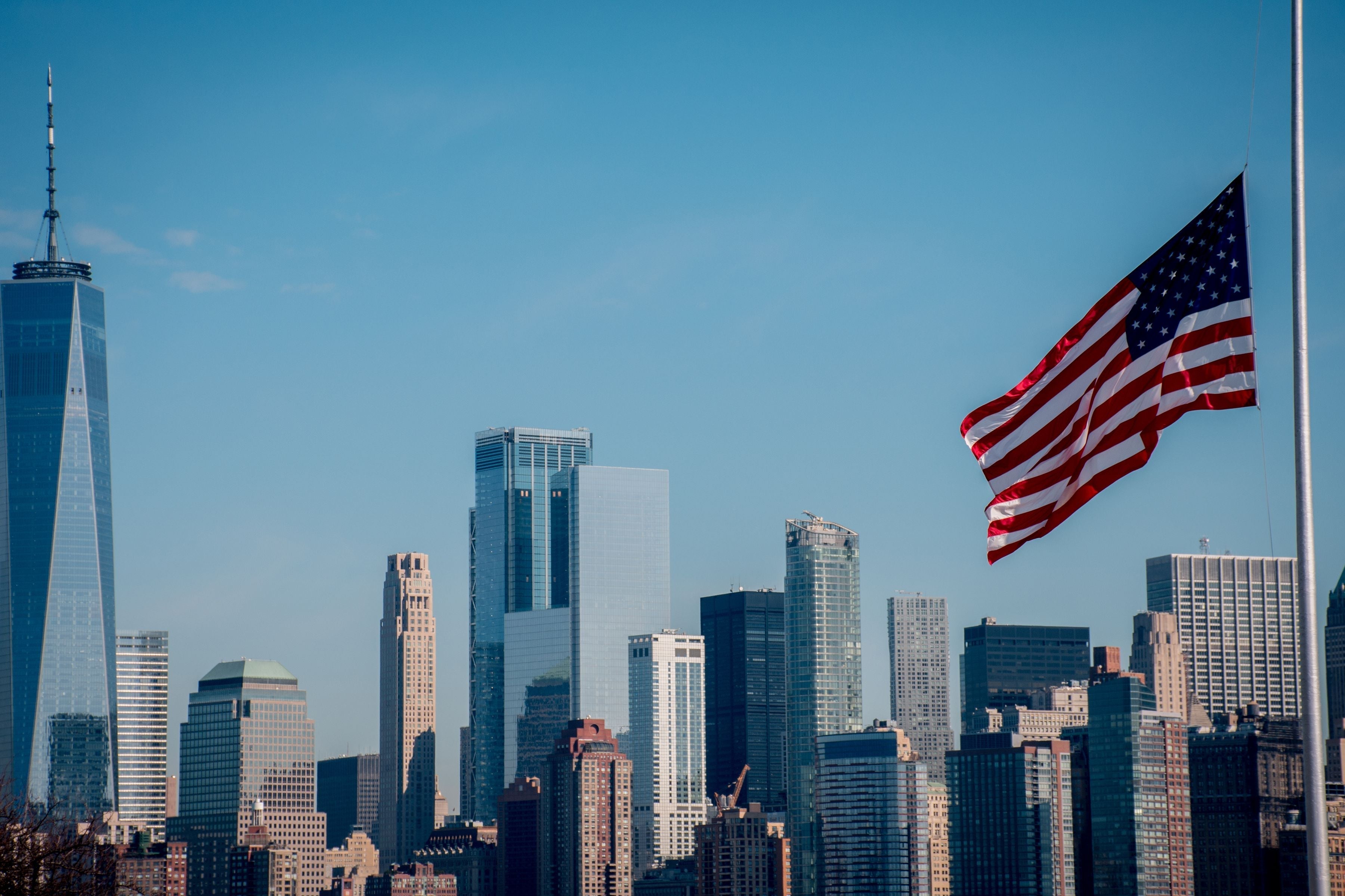 City skyline with American flag waving in the foreground